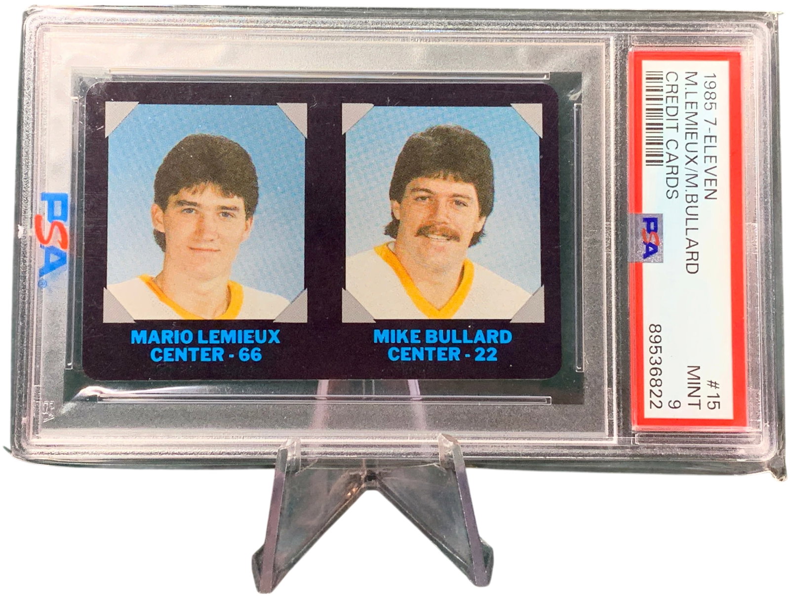 1985 7-Eleven NHL Collectors Series #15 Mario Lemieux and Mike Bullard PSA MINT 9: A 1985 7-Eleven NHL Collectors' Series trading card, number 15 of 25, featuring Pittsburgh Penguins centers Mario Lemieux and Mike Bullard. This card is from Mario Lemieux's rookie era and is designed