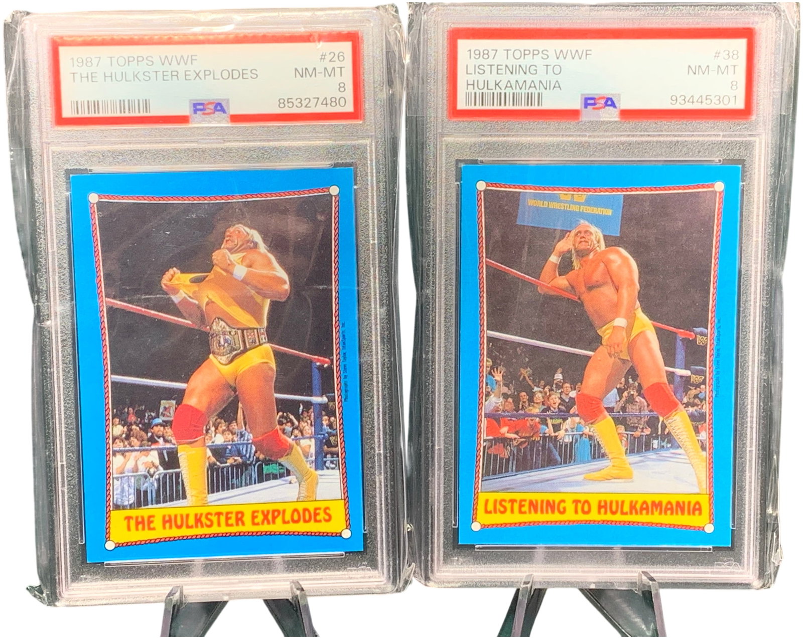 1987 Topps WWF Hulk Hogan Cards #26 and #38 Graded PSA 8 NM-MT: This lot features professionally graded trading cards from the 1987 Topps World Wrestling Federation (WWF) series, both featuring Hulk Hogan. The first card is #26, titled "The Hulkster Explodes," dep