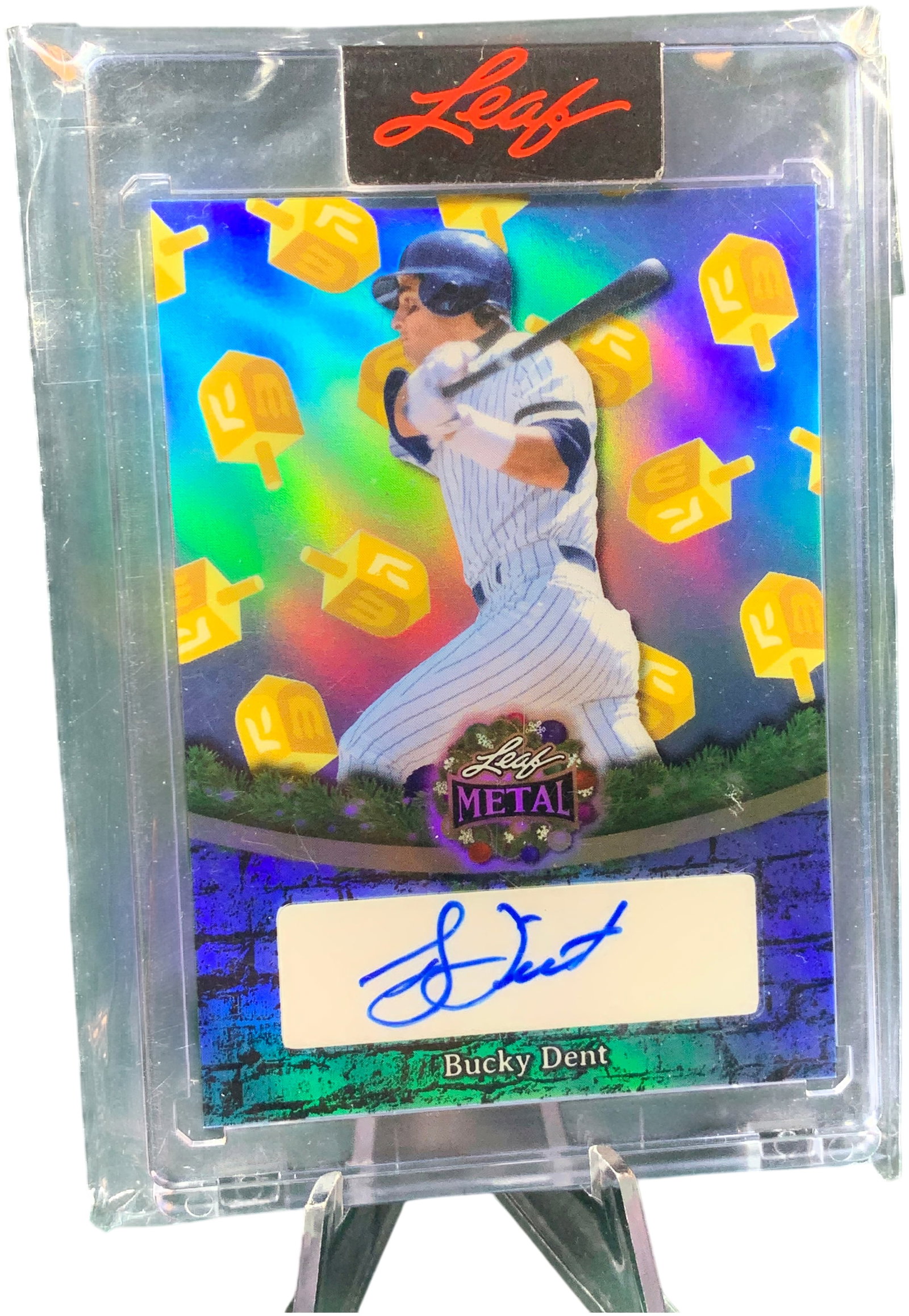 2023 Leaf Metal Baseball Bucky Dent Sticker Autograph Dreidel Parallel Hand-Numbered 2/3: This 2023 Leaf Metal Baseball card features former professional player Bucky Dent. The card is a limited-edition holiday-themed Dreidel parallel, part of a Hanukkah-inspired set. The front of the card