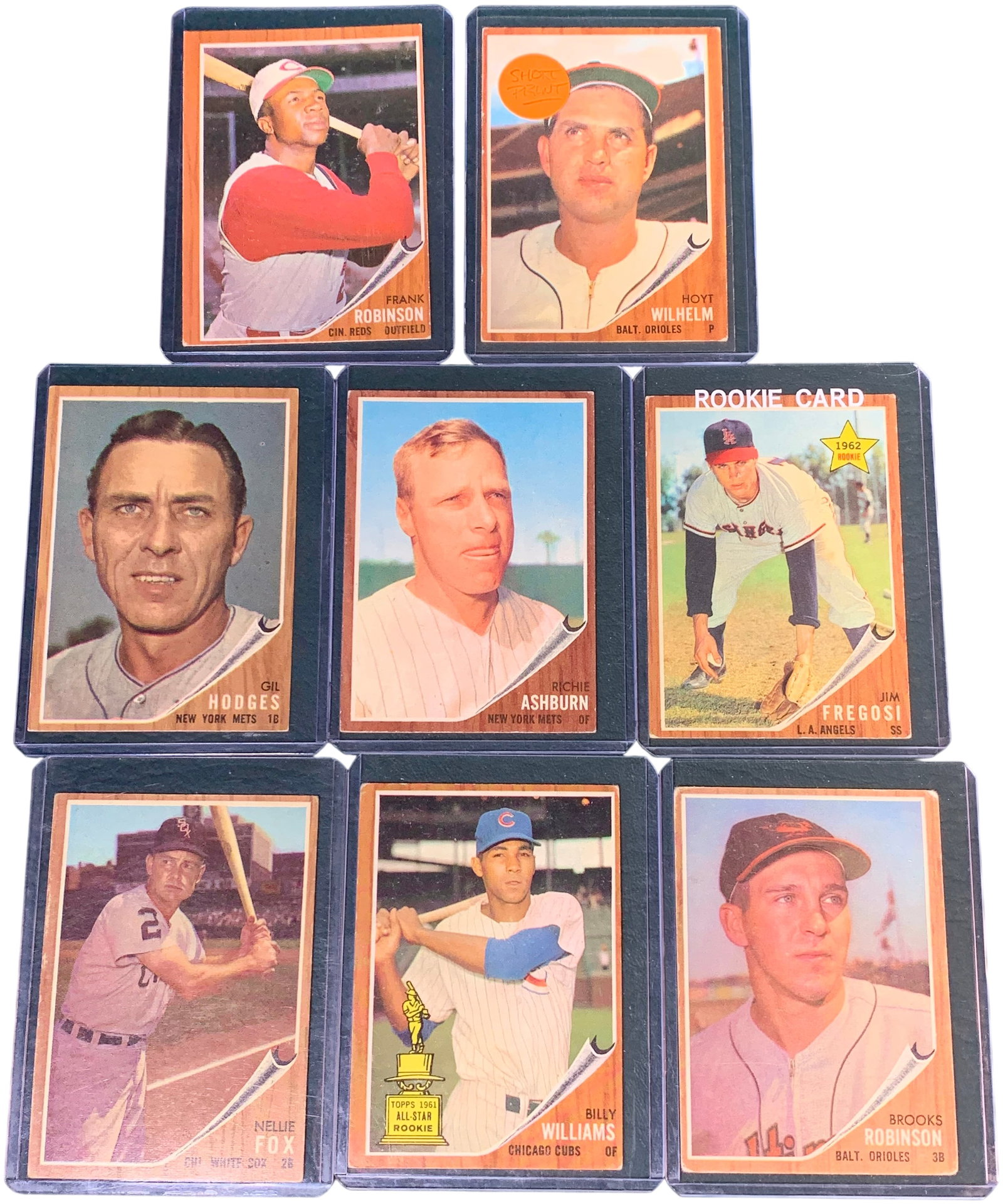 A Collection of Eight 1962 Topps Baseball Cards Including Hall of Famers and High Number Short Print: This group consists of vintage baseball cards from the 1962 Topps set, recognized by its distinctive wood-grain border design. The collection features several Hall of Fame inductees and key star cards