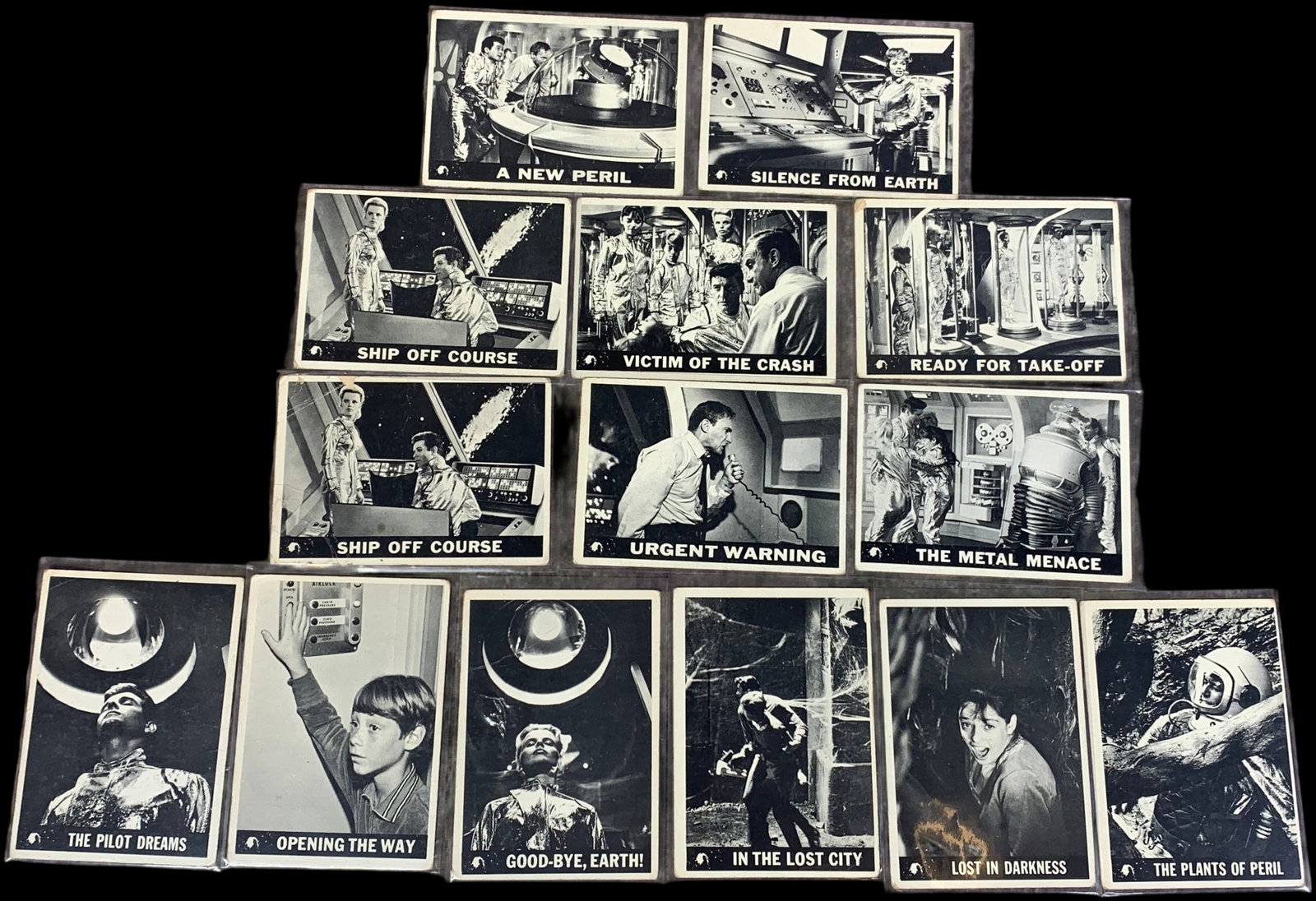 A Collection of 14 Vintage 1966 Topps Lost in Space Trading Cards: A collection of vintage non-sport trading cards from the 1966 series based on the science fiction television program Lost in Space. The cards feature black and white photographic stills from the serie