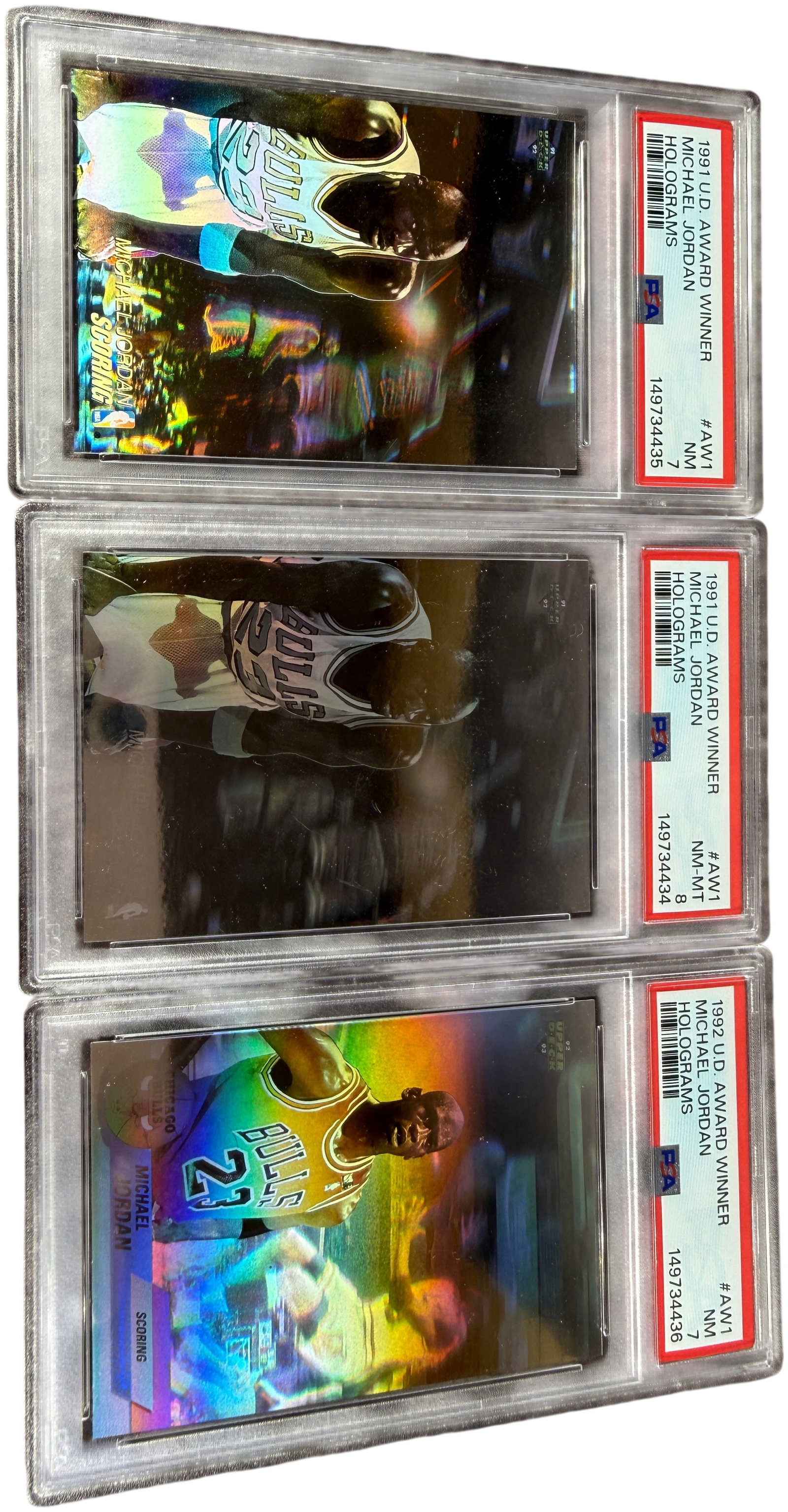 A Trio of 1991 and 1992 Michael Jordan Upper Deck Award Winner Hologram Cards PSA 7 and 8: This lot features Michael Jordan holographic insert cards from the early 1990s Upper Deck basketball sets, all professionally authenticated and graded by PSA. The collection contains examples from the