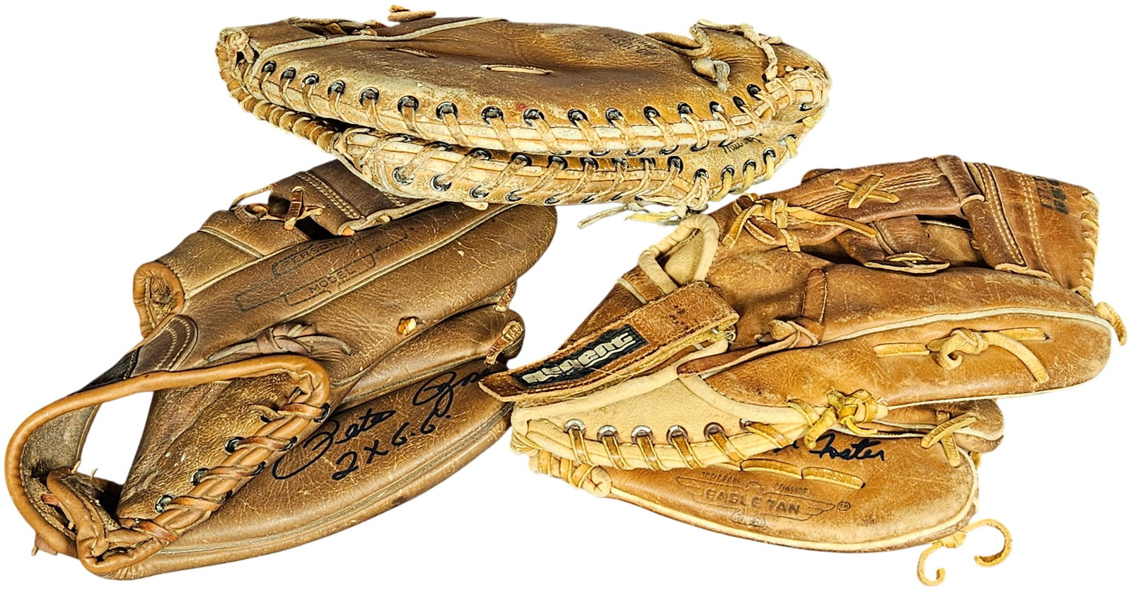 A Trio of Vintage Baseball Gloves Including Pete Rose and George Foster Signature Models: This lot consists of vintage leather baseball gloves, including fielder's gloves and a catcher's mitt. The first fielder's glove is a Pete Rose signature model, featuring a printed Pete Rose signature