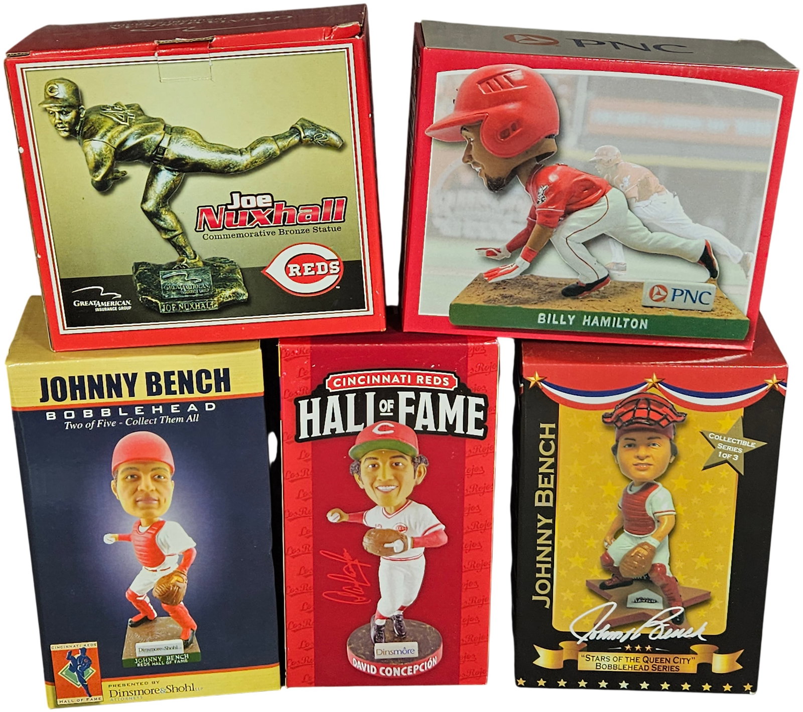 A Collection of Cincinnati Reds Bobbleheads and Commemorative Statues: An assortment of Cincinnati Reds baseball collectibles featuring various players and series. The collection includes a Joe Nuxhall commemorative bronze-finish statue sponsored by Great American Insura