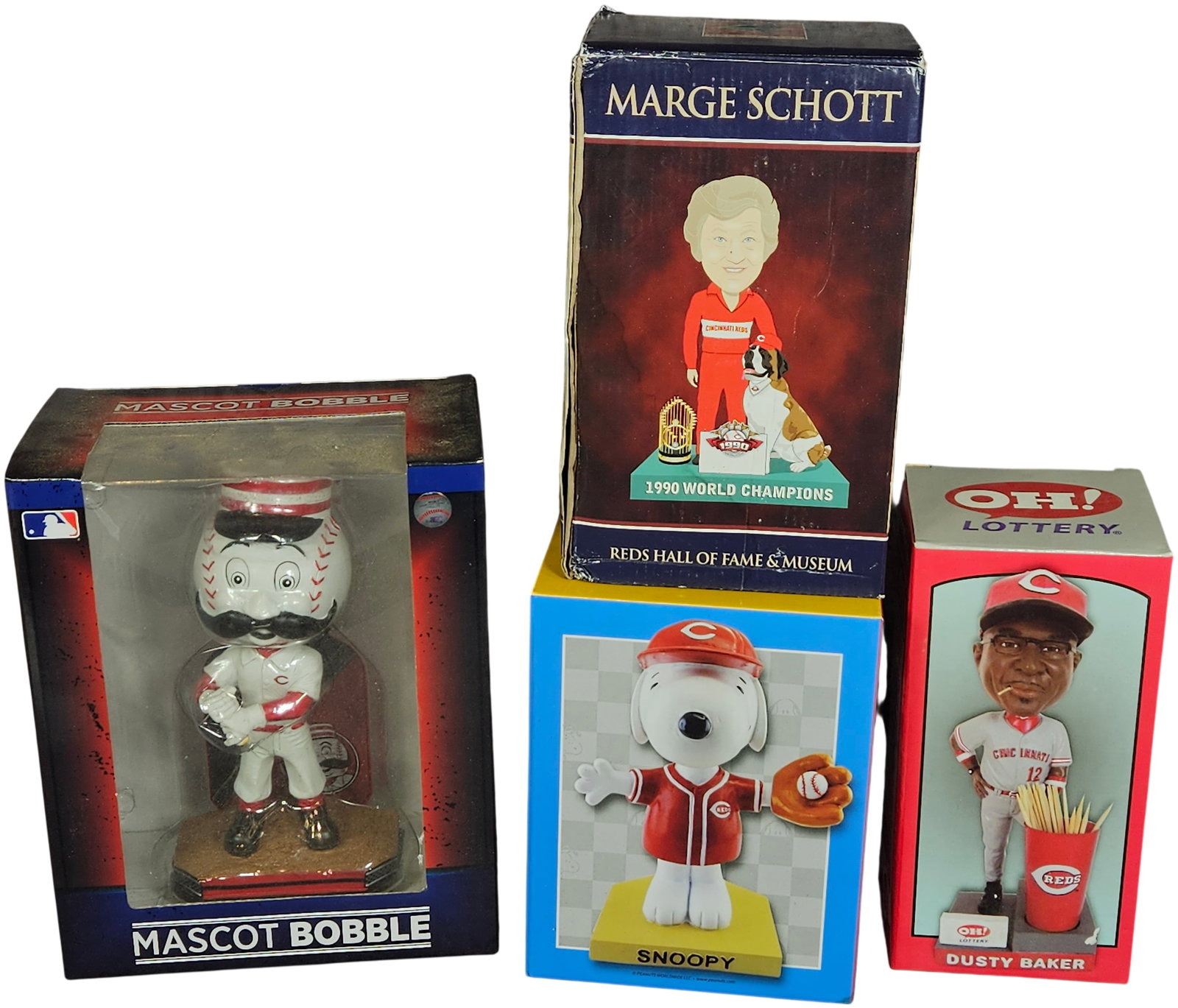 A Collection of Cincinnati Reds Bobbleheads and Figurines including Mr. Redlegs, Marge Schott, Dusty: A collection of Cincinnati Reds themed bobbleheads and figurines in their original retail packaging. The group features a Mr. Redlegs Mascot Bobble in a classic pinstripe uniform with a baseball-shape