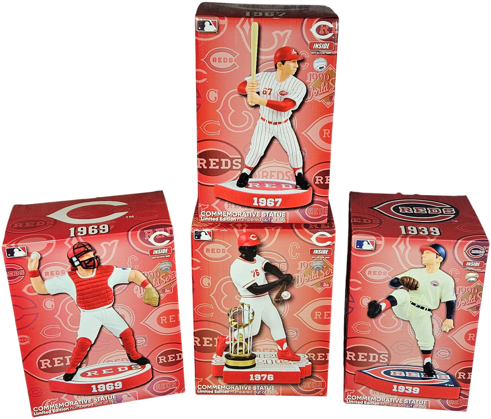 A Collection of Cincinnati Reds Limited Edition Commemorative Baseball Statues: A collection of Cincinnati Reds commemorative baseball statues, celebrating significant years in franchise history. Each statue is housed in its original red-and-white illustrated packaging featuring 