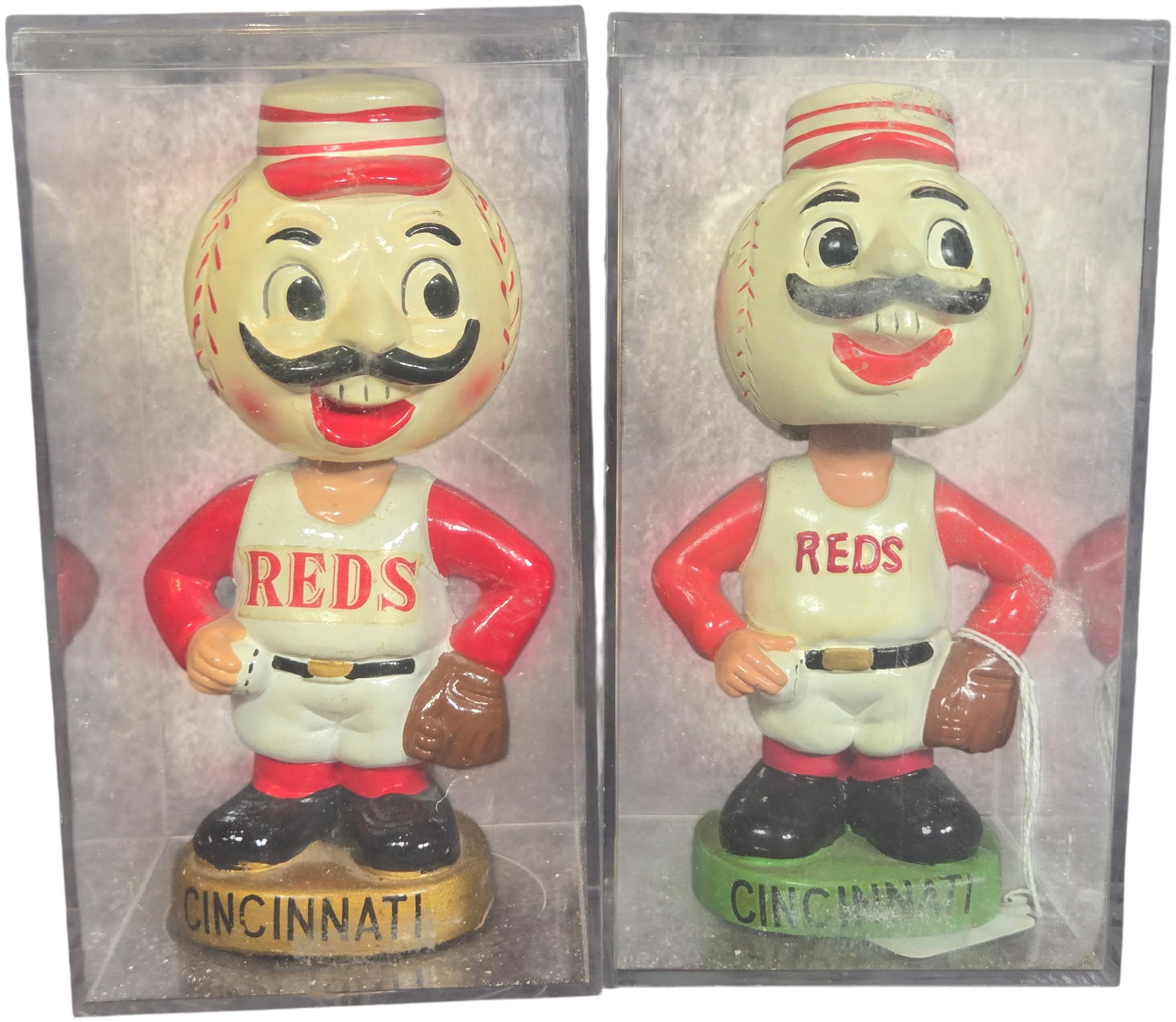 A Pair of Vintage Sports Specialties Cincinnati Reds Mr. Redlegs Bobbleheads: A pair of vintage composition material bobbleheads manufactured by Sports Specialties, depicting the Cincinnati Reds mascot known as Mr. Redlegs. Each figure features a baseball-shaped head with a bla