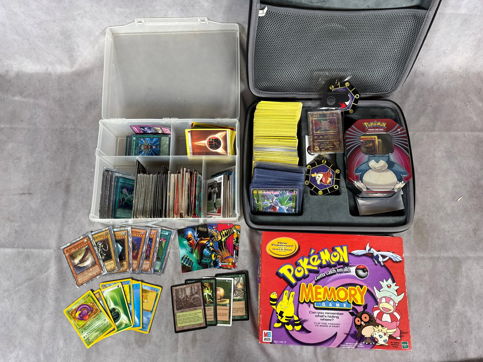 A Collection of Trading Cards and Gaming Accessories Including Pokemon Yu-Gi-Oh Magic The Gathering: This is a diverse collection of trading cards, gaming accessories, and a vintage board game. The Pokemon TCG selection includes a holographic Ancient Mew promotional card featuring runic script and 19