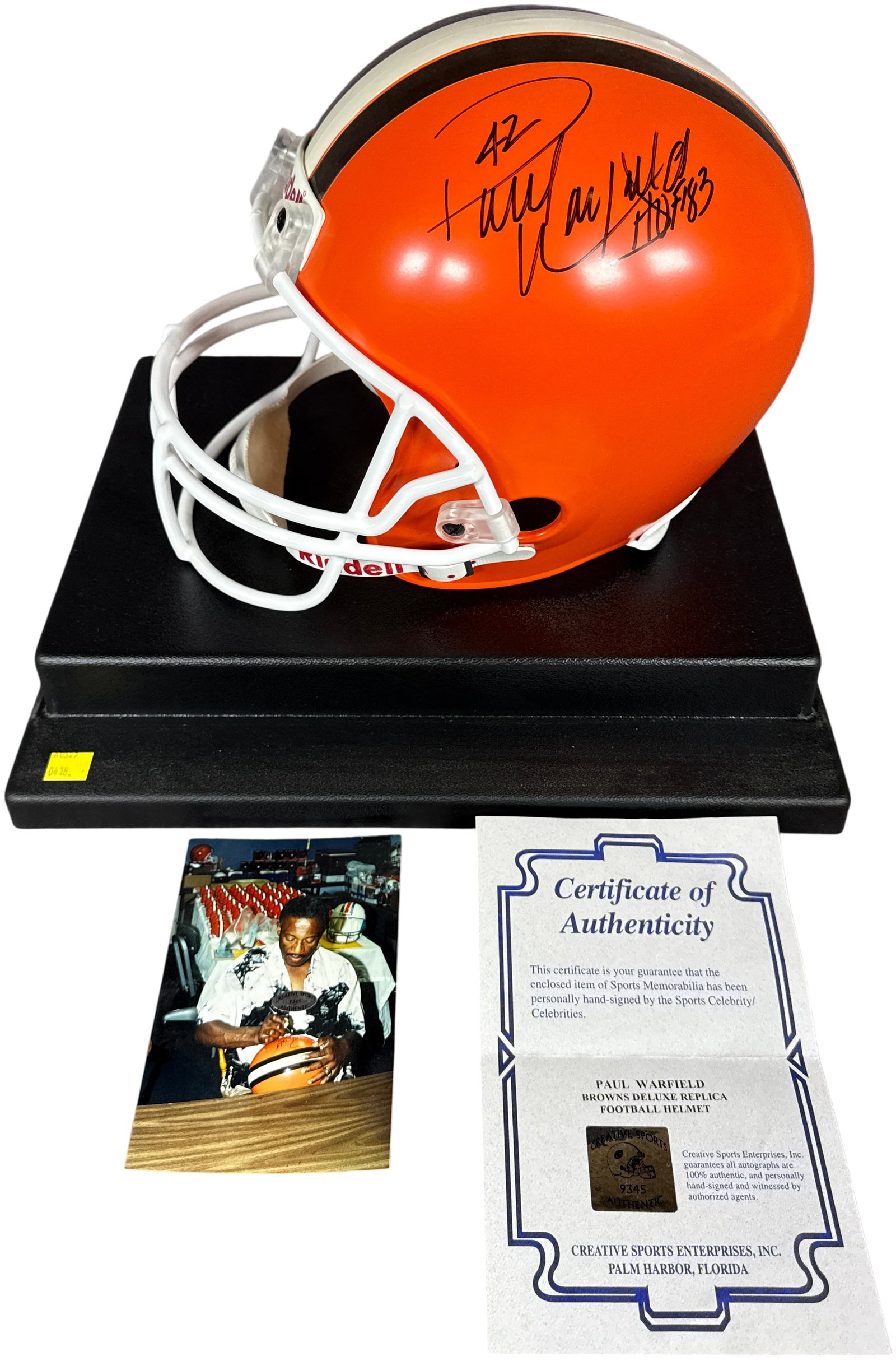 Paul Warfield Autographed Riddell Deluxe Replica Cleveland Browns Football Helmet in Display Case: This lot features a full-size Riddell deluxe replica Cleveland Browns football helmet, hand-signed by Hall of Fame wide receiver Paul Warfield. The helmet is constructed with an orange shell, brown an