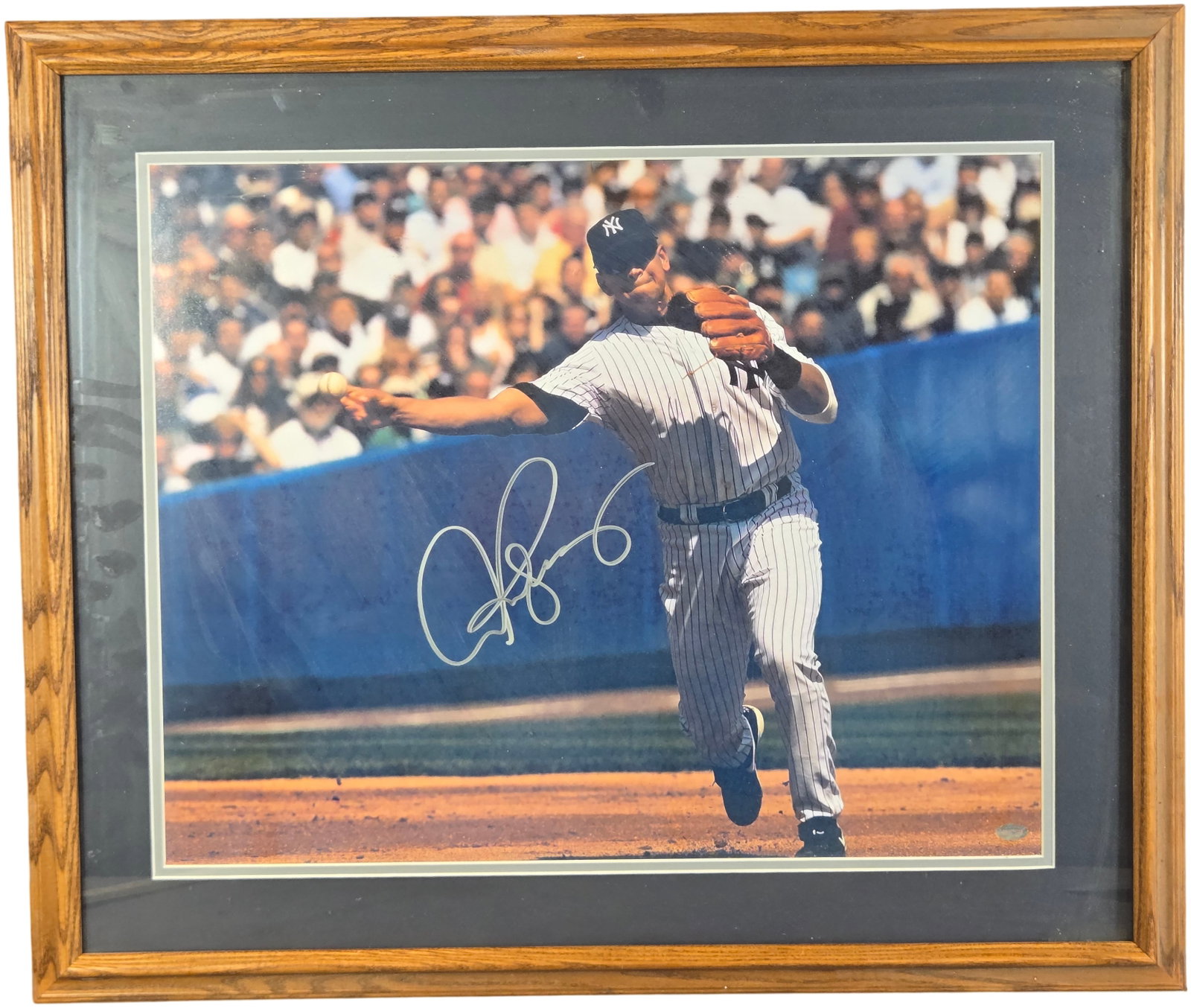 Derek Jeter Signed New York Yankees Action Photograph with Mounted Memories Authentication: This lot features a professionally framed and matted color photograph of New York Yankees shortstop Derek Jeter. The action shot captures Jeter performing his signature mid-air jump-throw, wearing the