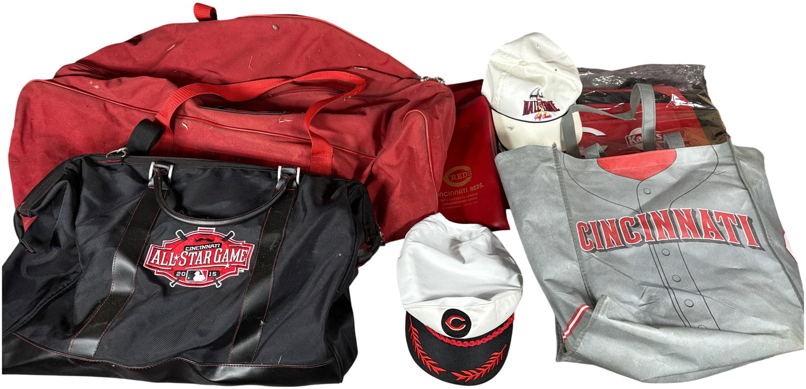 A Collection of Cincinnati Reds and Major League Baseball Commemorative Memorabilia Bags, Hats, and: This collection contains an assortment of commemorative items related to the Cincinnati Reds and Major League Baseball. Included is a black nylon duffel bag featuring embroidered and screen-printed lo
