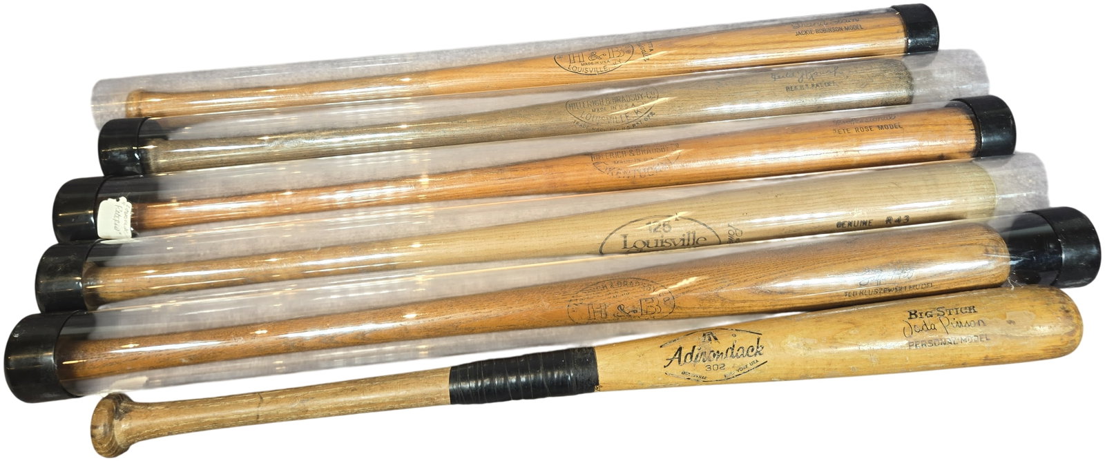 Collection of Vintage Wooden Baseball Bats Featuring Jackie Robinson and Pete Rose Models: A collection of vintage wooden baseball bats featuring various professional player models and factory-stamped signatures. The lot consists of five bats housed in clear plastic display tubes with black