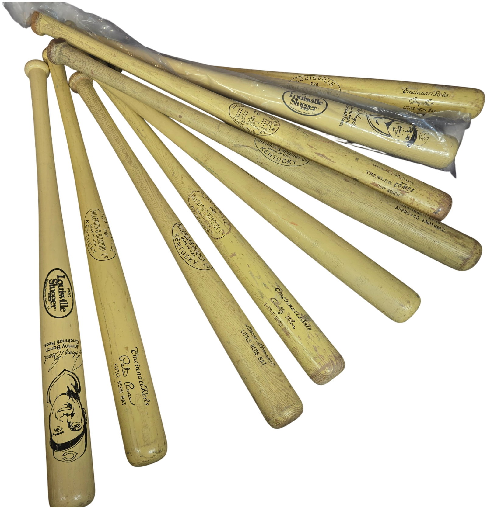 A Collection of Vintage Cincinnati Reds Souvenir and Junior Louisville Slugger Baseball Bats: This collection consists of several vintage wooden souvenir and junior baseball bats produced by Hillerich and Bradsby Co. under the Louisville Slugger brand, primarily themed after the Cincinnati