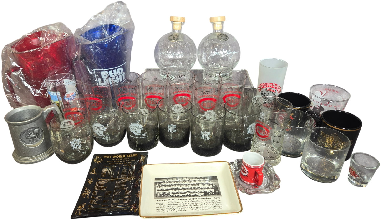A Collection of Cincinnati Reds and Cincinnati Bengals Commemorative Sports Memorabilia and Barware: A collection of professional sports memorabilia and barware centered on the Cincinnati Reds and Cincinnati Bengals franchises. The group includes two glass decanters molded in the shape of a baseball