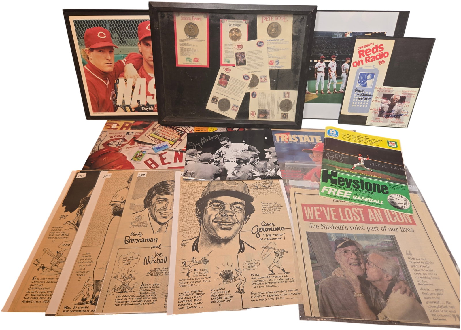 A Collection of Cincinnati Reds Baseball Memorabilia Featuring Autographed Items and Big Red Machine: An assortment of Cincinnati Reds baseball memorabilia primarily focused on the Big Red Machine era and the 1990 World Series championship team. The collection features a framed Dayton Daily News Nasty