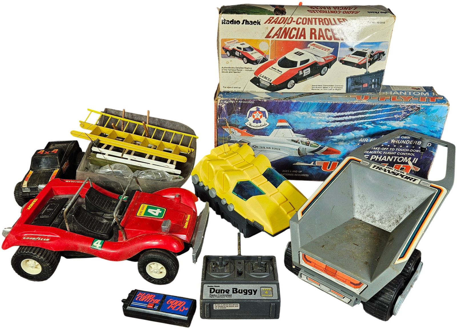 A Collection of Vintage Radio-Controlled Vehicles and Playsets featuring Radio Shack, Tandy, and: This collection consists of several vintage plastic toys and motorized sets primarily from the late 1970s and 1980s. The lot includes a Radio Shack Radio-Controlled Lancia Racer (Cat. No. 60-3042), wh