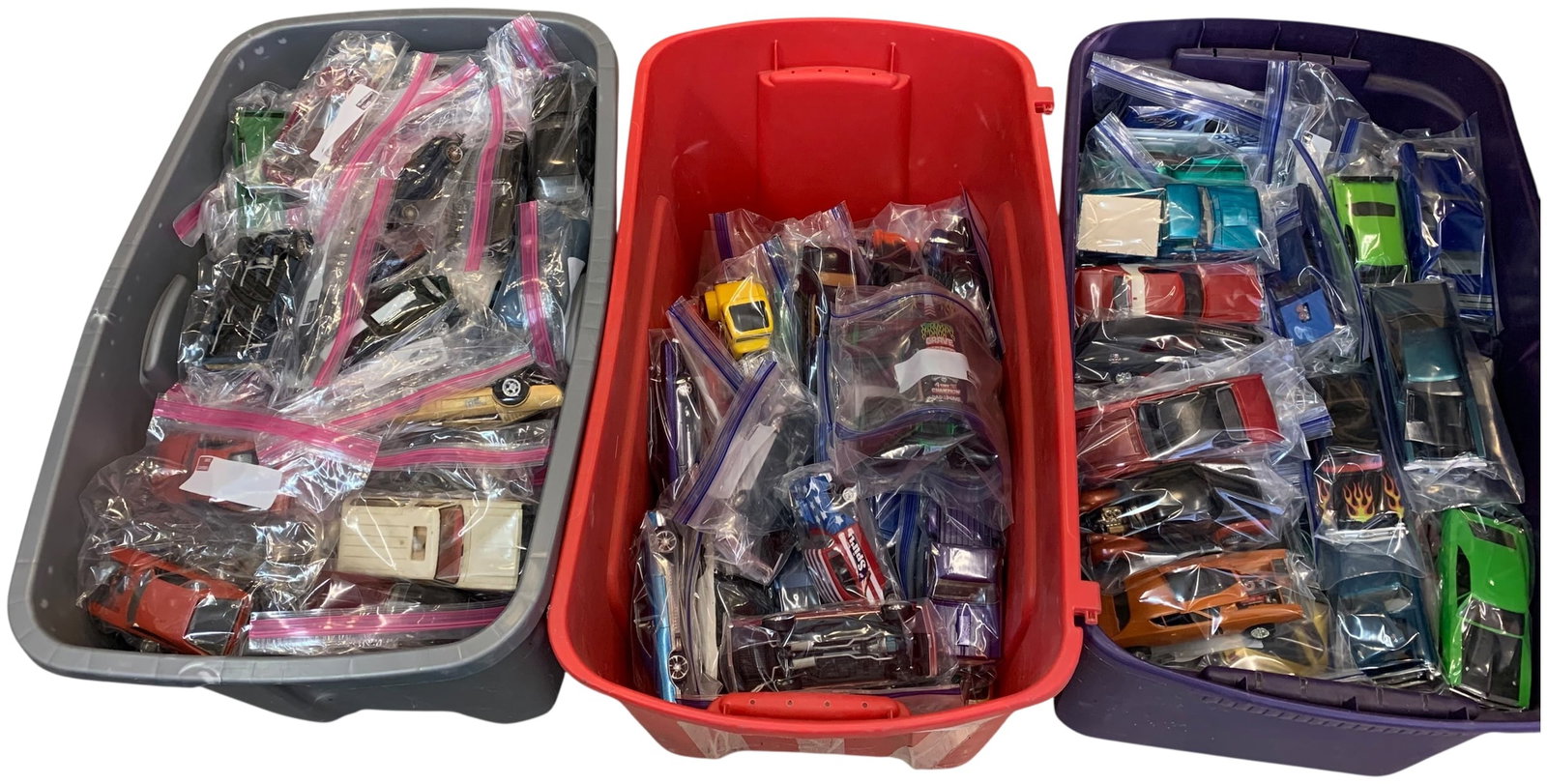 A Collection of Assembled Plastic Model Cars and Trucks: A large group of assorted assembled plastic model cars and trucks in various colors and styles including vehicles with Grave Digger and the Spirit decals, individually bagged and stored in plastic bin
