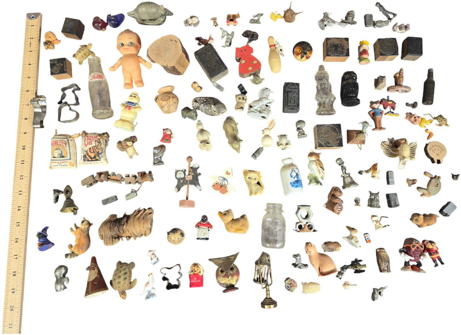 An Assortment of Vintage Miniature Figurines Shadow Box Trinkets and Curiosities: An assortment of vintage miniature figurines, trinkets, and curiosities crafted from various materials including pewter, ceramic, wood, glass, vinyl, and plastic. The collection features a diverse ran