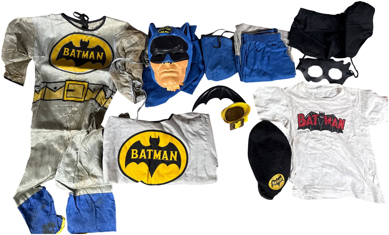 An Assortment of Vintage Batman Licensed Costumes and Accessories Including Arlington Hat, circa: This collection contains various licensed Batman apparel and toy items produced during the 1966 television era. The primary garment is a gray synthetic fabric children's jumpsuit featuring a printed y