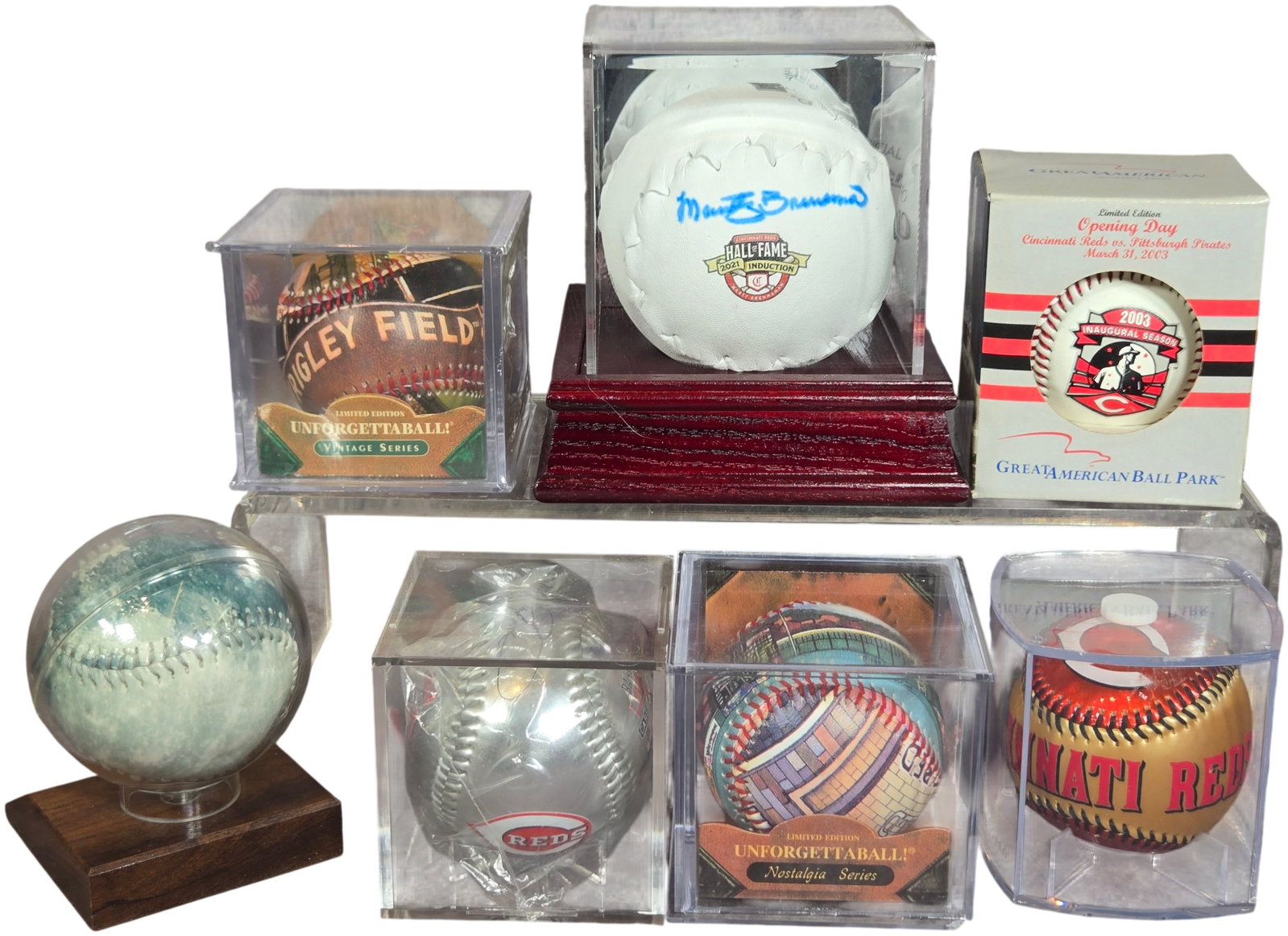 A Collection of Cincinnati Reds Autographed and Commemorative Baseball Memorabilia: This collection features a variety of Cincinnati Reds commemorative and autographed baseballs. Included is an Official Clincher baseball signed in blue ink by Marty Brennaman, bearing a 2021 Induction