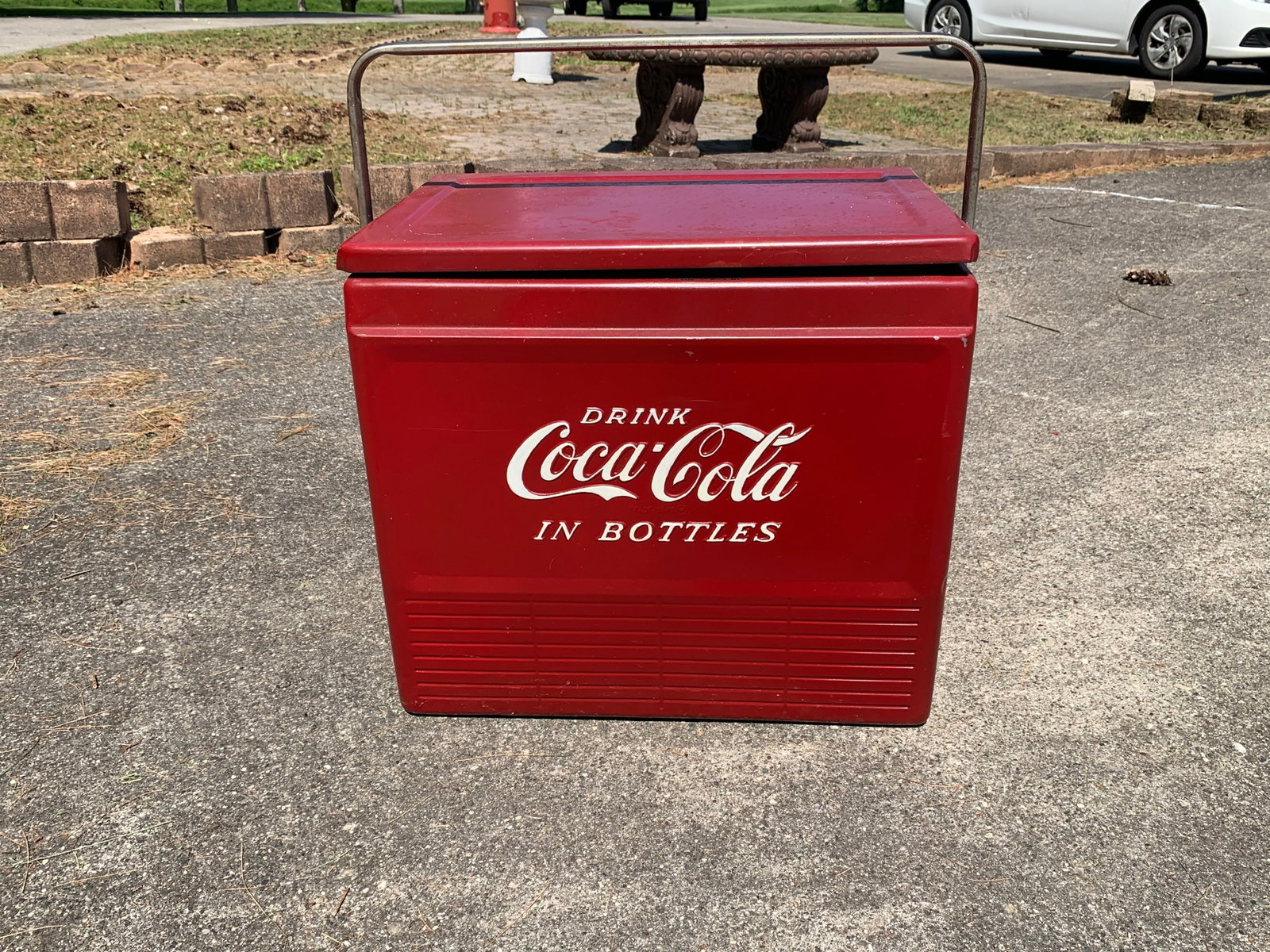 Vintage Coca-Cola Metal Picnic Cooler Attributed to Progress Refrigerator Co.: This mid-20th century portable metal ice chest features a steel body finished in classic Coca-Cola red with white embossed lettering. The front and back panels are prominently marked with DRINK Coca-C