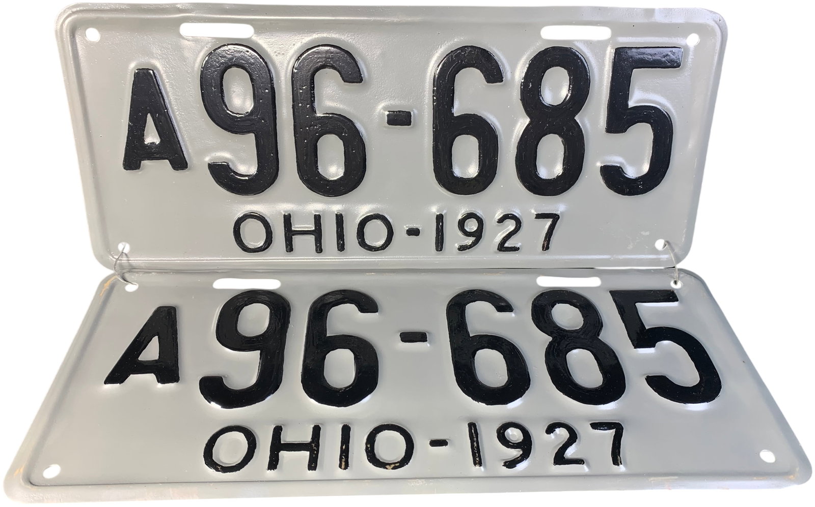 A Pair of 1927 Ohio Passenger Vehicle License Plates: This is a matched pair of vintage motor vehicle registration plates issued by the state of Ohio in 1927. The plates are constructed of stamped metal with a grey painted background and embossed black c