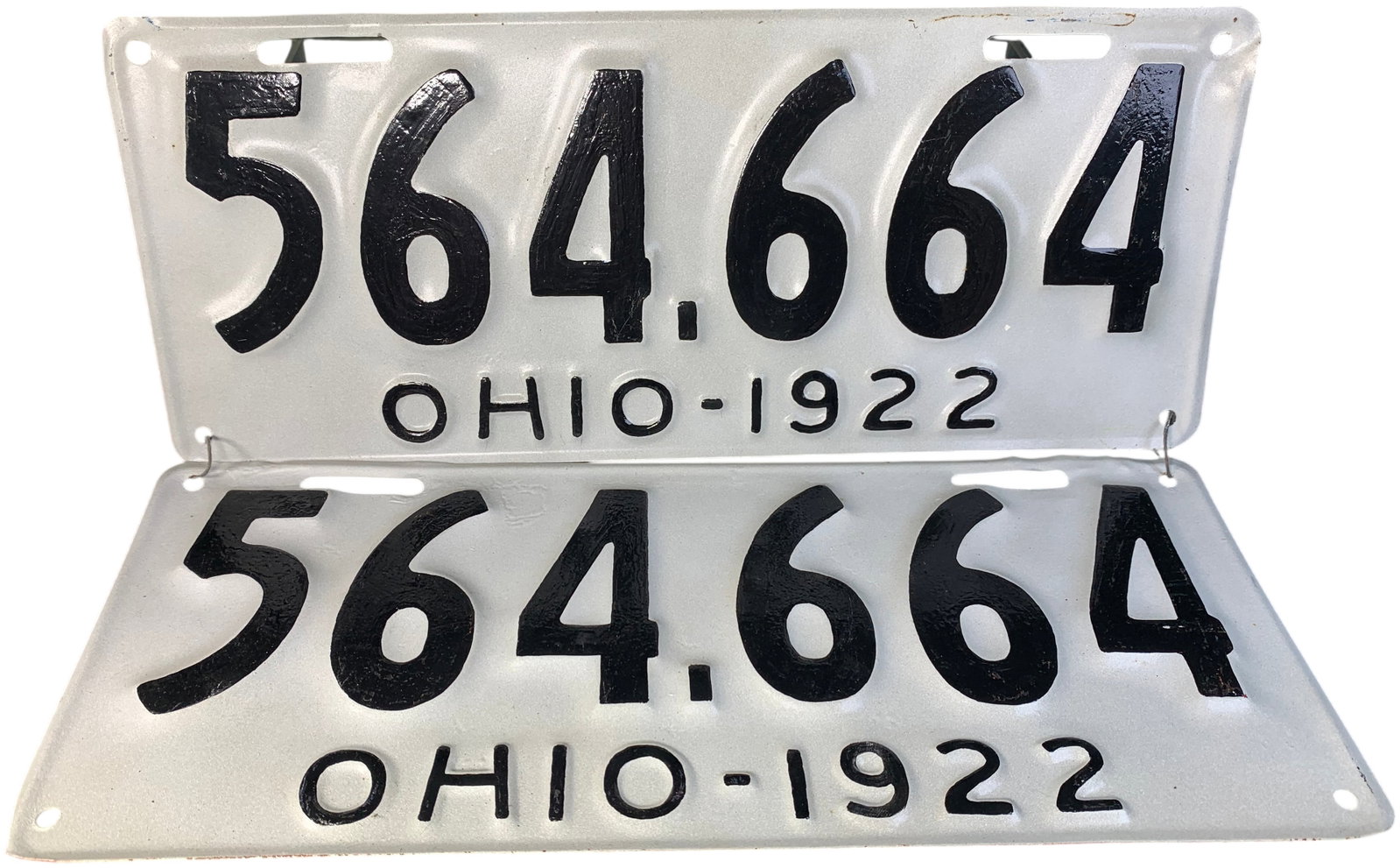A Pair of 1922 Ohio Passenger Vehicle License Plates: This lot features a pair of matching embossed steel passenger vehicle license plates issued by the state of Ohio for the year 1922. The plates are finished in a white background with black embossed al