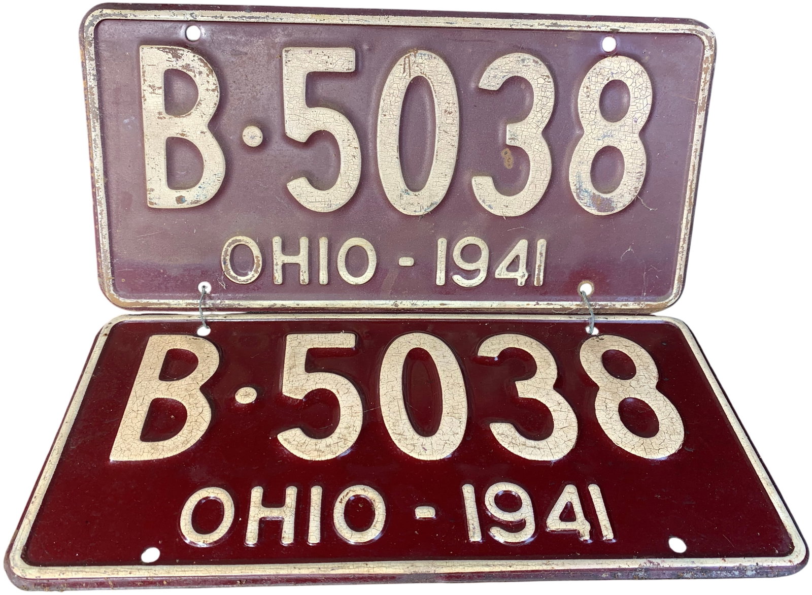 A Pair of Vintage 1941 Ohio Passenger Vehicle License Plates B-5038: This lot features a matching pair of embossed steel license plates issued by the state of Ohio for the year 1941. The plates are characterized by a deep maroon background with embossed alphanumeric ch