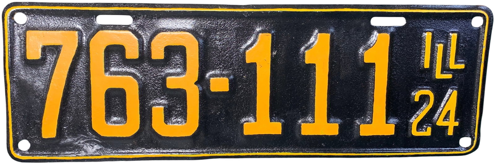 1924 Illinois Passenger Vehicle License Plate: A vintage 1924 Illinois passenger vehicle license plate. The plate is constructed of embossed metal featuring the registration number 763-111 in large centered digits. On the right side, the state abb