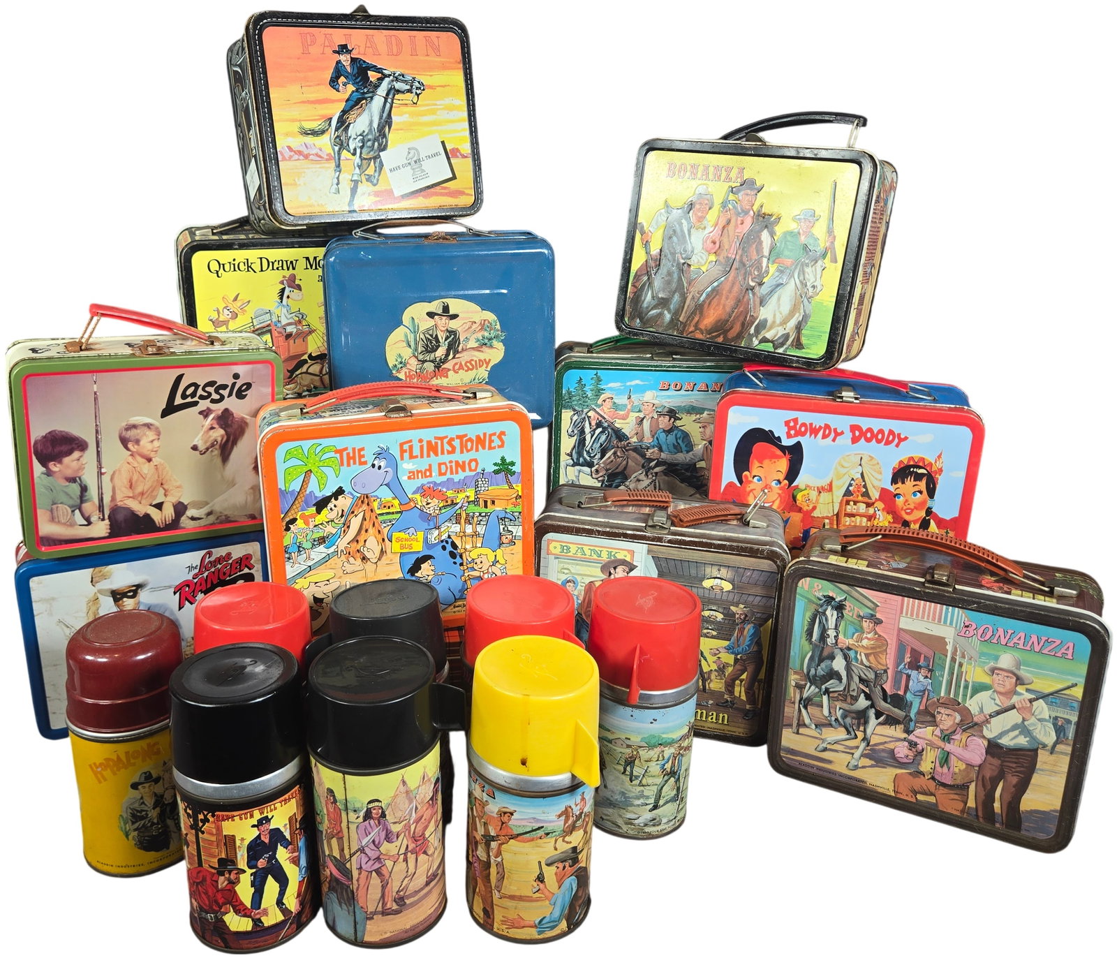 A collection of Vintage Aladdin Industries Tin Lunchboxes and Seven Thermoses: This lot consists of a collection of vintage lithographed tin lunchboxes and a group of matching thermoses, primarily produced by Aladdin Industries Incorporated of Nashville, Tennessee. The collectio