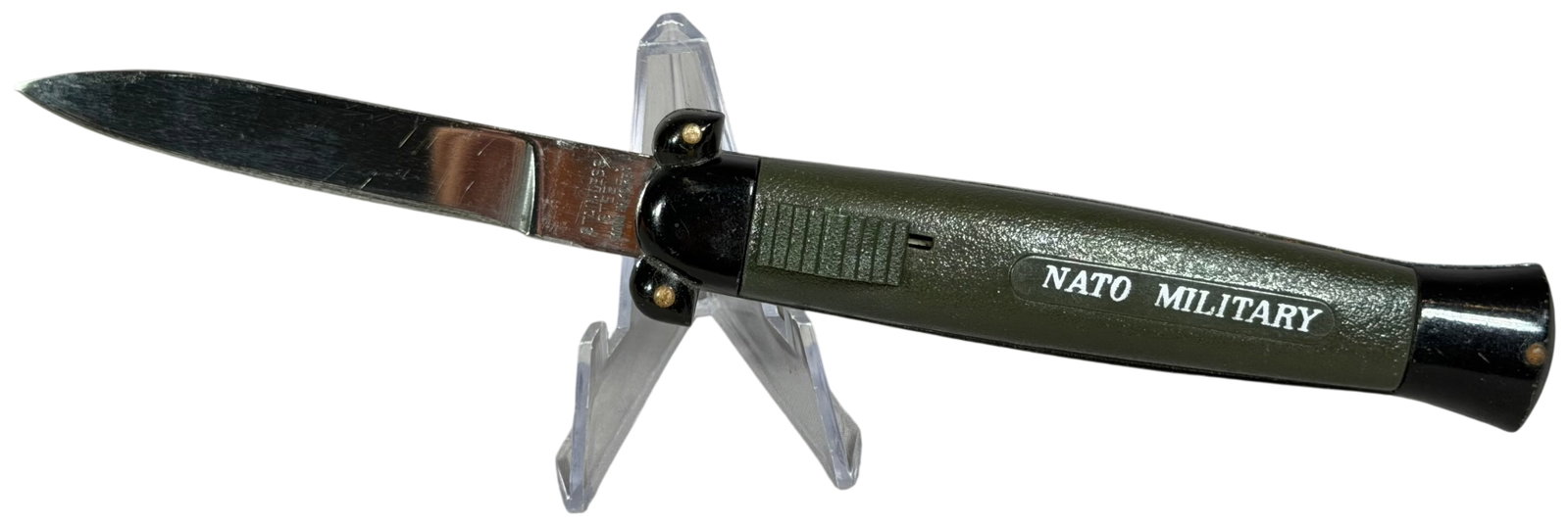 NATO Military Automatic Side-Opening Folding Knife Made in Korea: A commercial Cold War era automatic folding knife featuring the NATO Military branding. This side-opening model consists of a stainless steel spear-point blade and a two-tone plastic handle. The