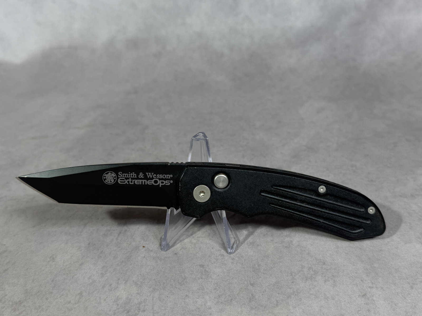 Smith & Wesson Extreme Ops Performance Automatic Tanto Folding Knife: Smith & Wesson Extreme Ops single blade automatic folding pocket knife. The black coated blade features a tanto point profile and is marked Smith & Wesson ExtremeOps on the obverse. The reverse side b