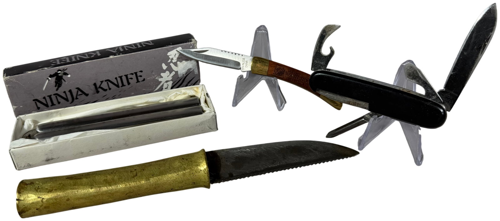 Four Folding and Fixed Blade Knives including Valor Ninja Balisong and Solingen Multi-Tool: This lot consists of four diverse knives featuring a Japanese-made balisong, a German multi-tool, a small lockback folder, and a fixed blade utility knife. The first item is a Valor Ninja balisong but