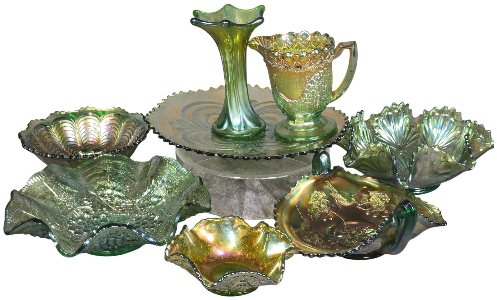 An Assortment of Eight Green Iridescent Carnival Glass Pieces Including Uranium Glass: An assortment of eight pieces of antique green iridescent carnival glass. This collection of pressed glass includes several documented patterns from major manufacturers of the early 20th century. Feat