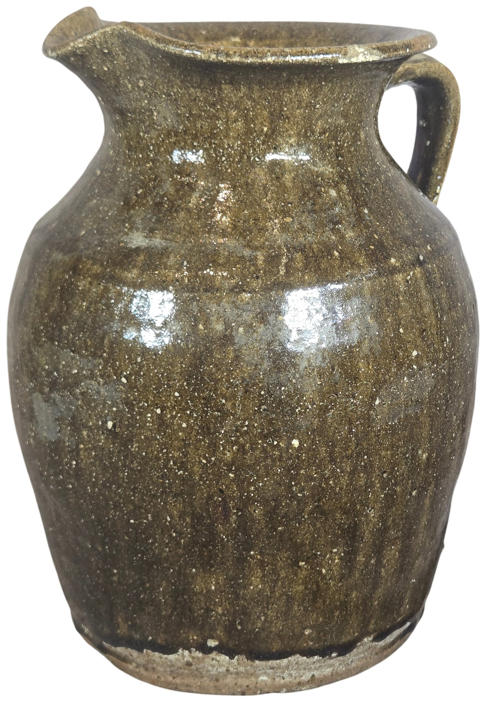 Southern Folk Pottery Alkaline Glazed Stoneware Pitcher: A hand-thrown stoneware pitcher featuring an ovoid body that tapers to a flared neck and rim. The vessel is constructed with a pinched pouring spout and a single vertical strap handle. The exterior is