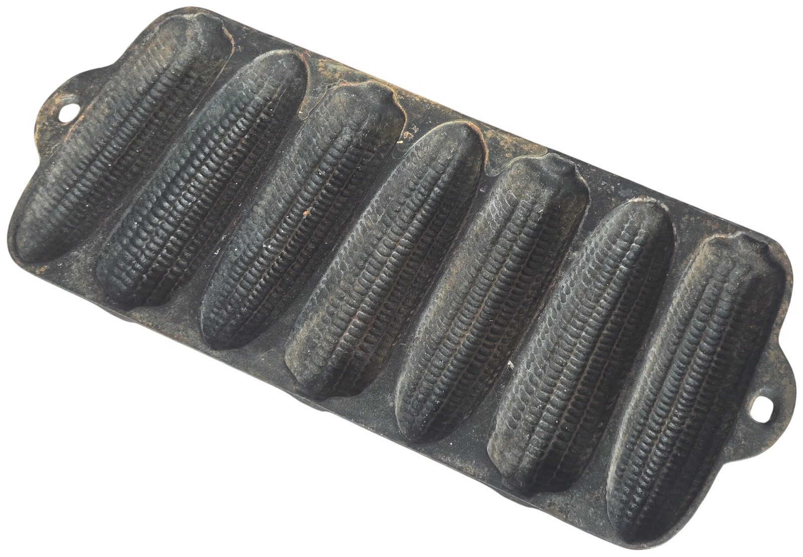 Vintage Cast Iron Seven Ear Corn Stick Baking Pan: A vintage cast iron baking pan featuring seven individual molds designed in the shape of stylized ears of corn for producing corn sticks. The piece is a single solid sand-casting with integrated handl