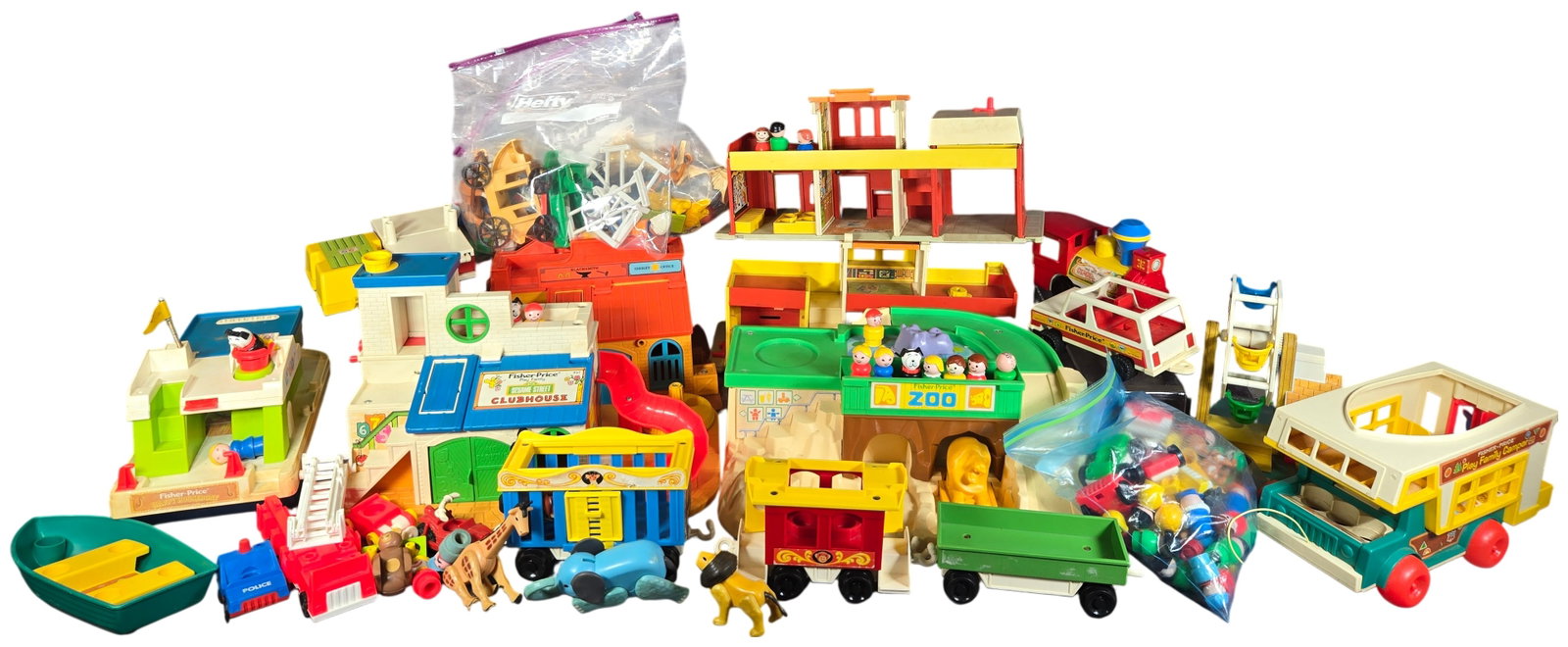 A Collection of Vintage Fisher-Price Little People Play Family Playsets and Accessories: A collection of vintage Fisher-Price Little People Play Family playsets, vehicles, and figures, primarily dating from the 1970s. The assortment includes several major playsets such as the Sesame Stree
