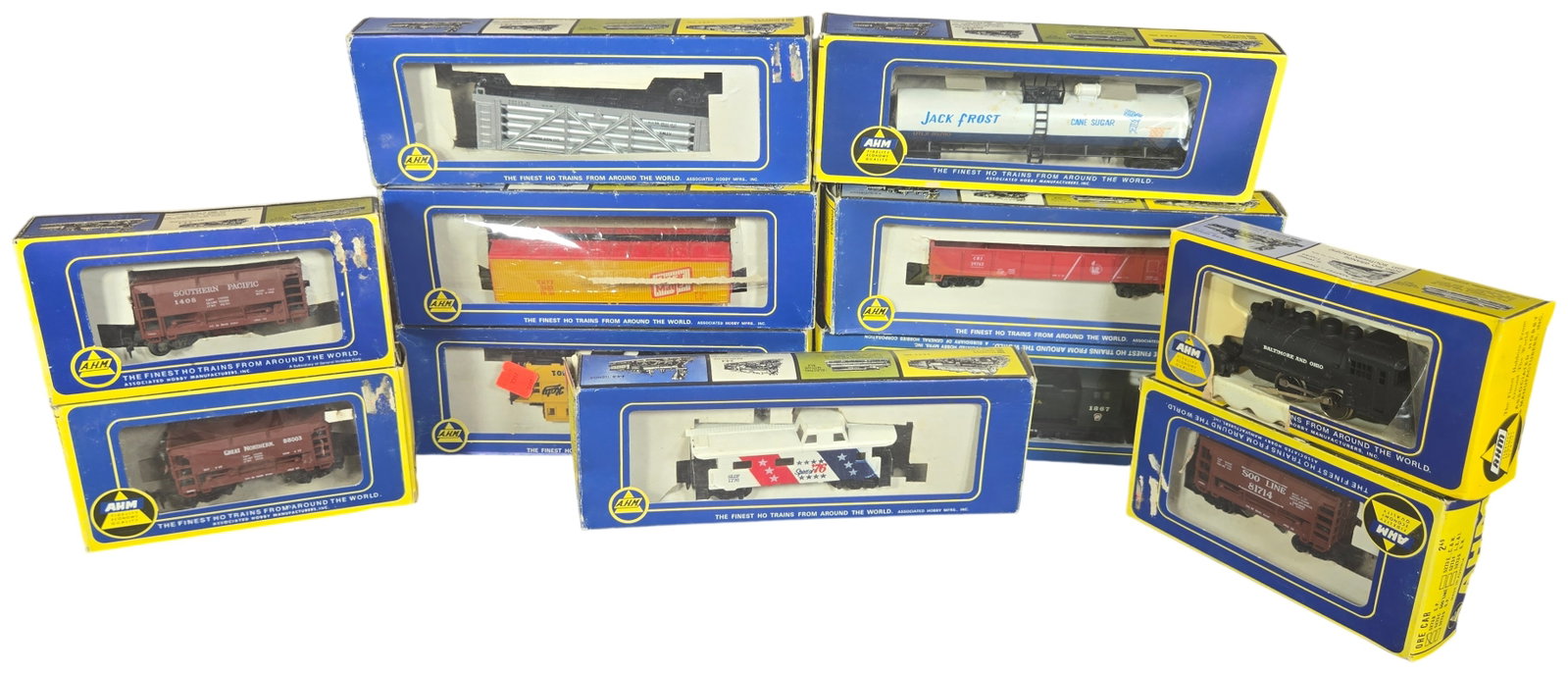 A Collection of Eleven AHM HO Scale Model Locomotives and Rolling Stock in Original Boxes: This collection consists of eleven HO scale model train pieces manufactured by Associated Hobby Manufacturers, Inc. (AHM). The assembly includes two locomotives and nine assorted freight cars and cabo
