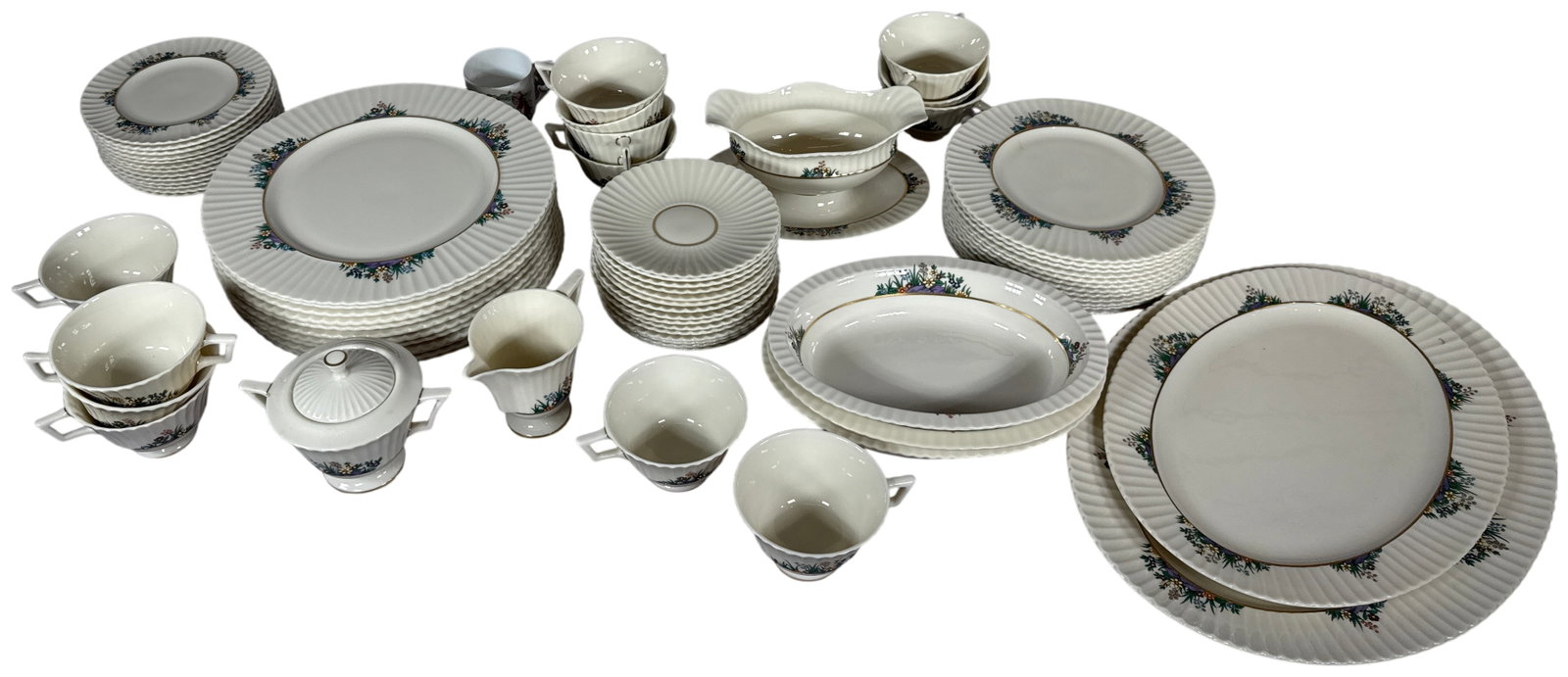 Lenox Rutledge Porcelain Dinnerware Service and Additional Mugs: A large porcelain dinnerware service produced by Lenox in the Rutledge pattern. The collection is crafted from ivory-toned porcelain with fluted bodies and scalloped rims. The decoration features mult