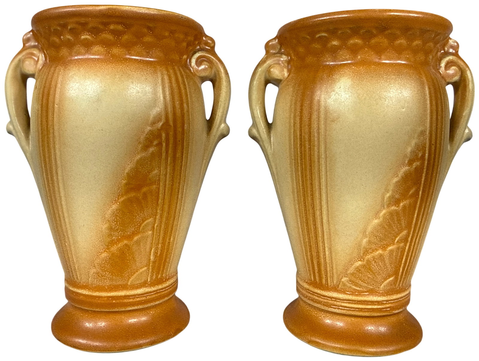 A Pair of Robinson Ransbottom Tionesta Pottery Vases: A matching pair of earthenware vases from the Tionesta line produced by Robinson Ransbottom Pottery Company. Each vase features a tapered urn form supported by a flared pedestal base. The body is deco