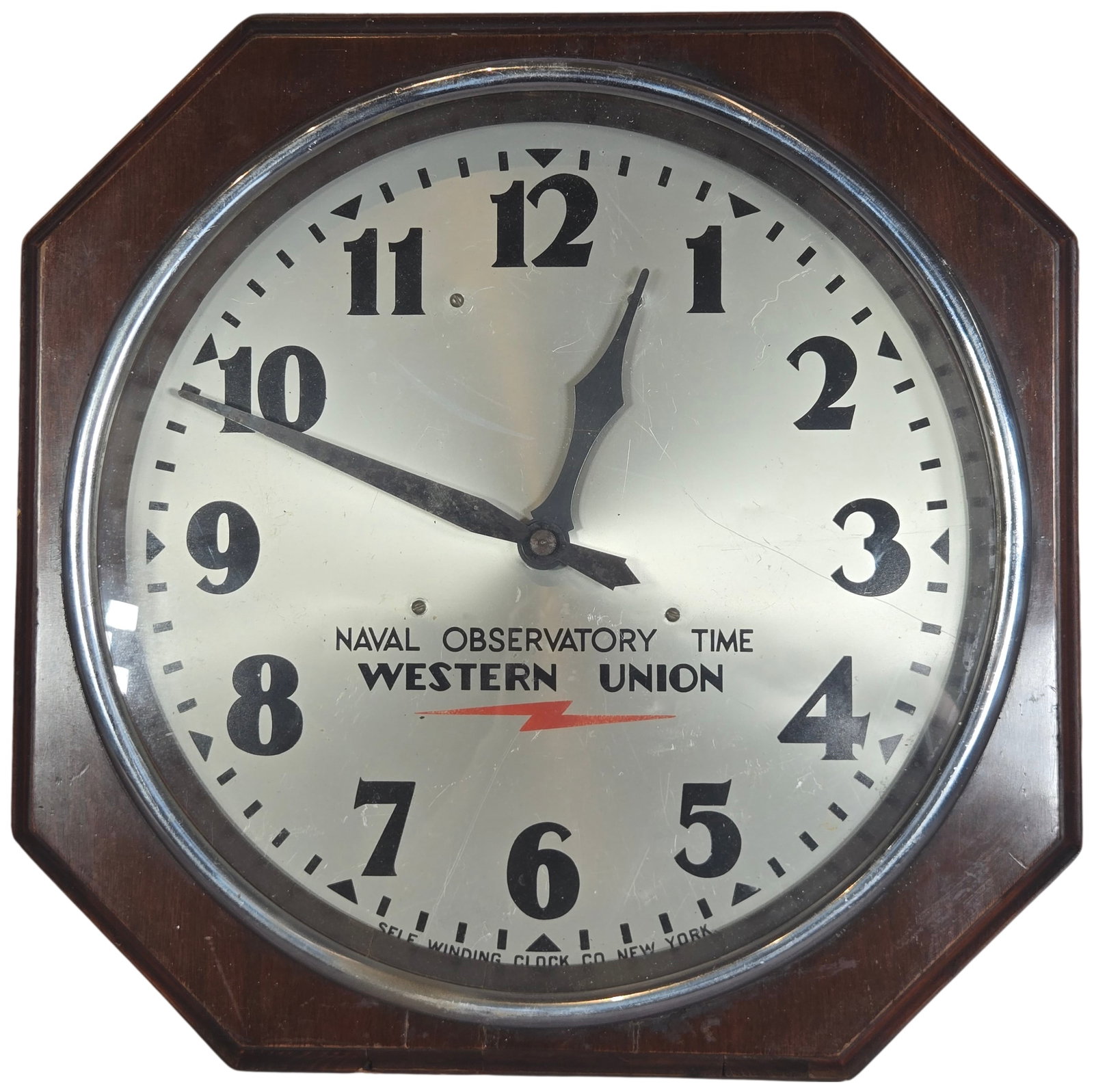 Self Winding Clock Co Western Union Naval Observatory Time Octagonal Wall Clock: This is an octagonal wall clock manufactured by the Self Winding Clock Co. of New York. The clock features a silvered metal dial prominently marked NAVAL OBSERVATORY TIME over WESTERN UNION with a cen