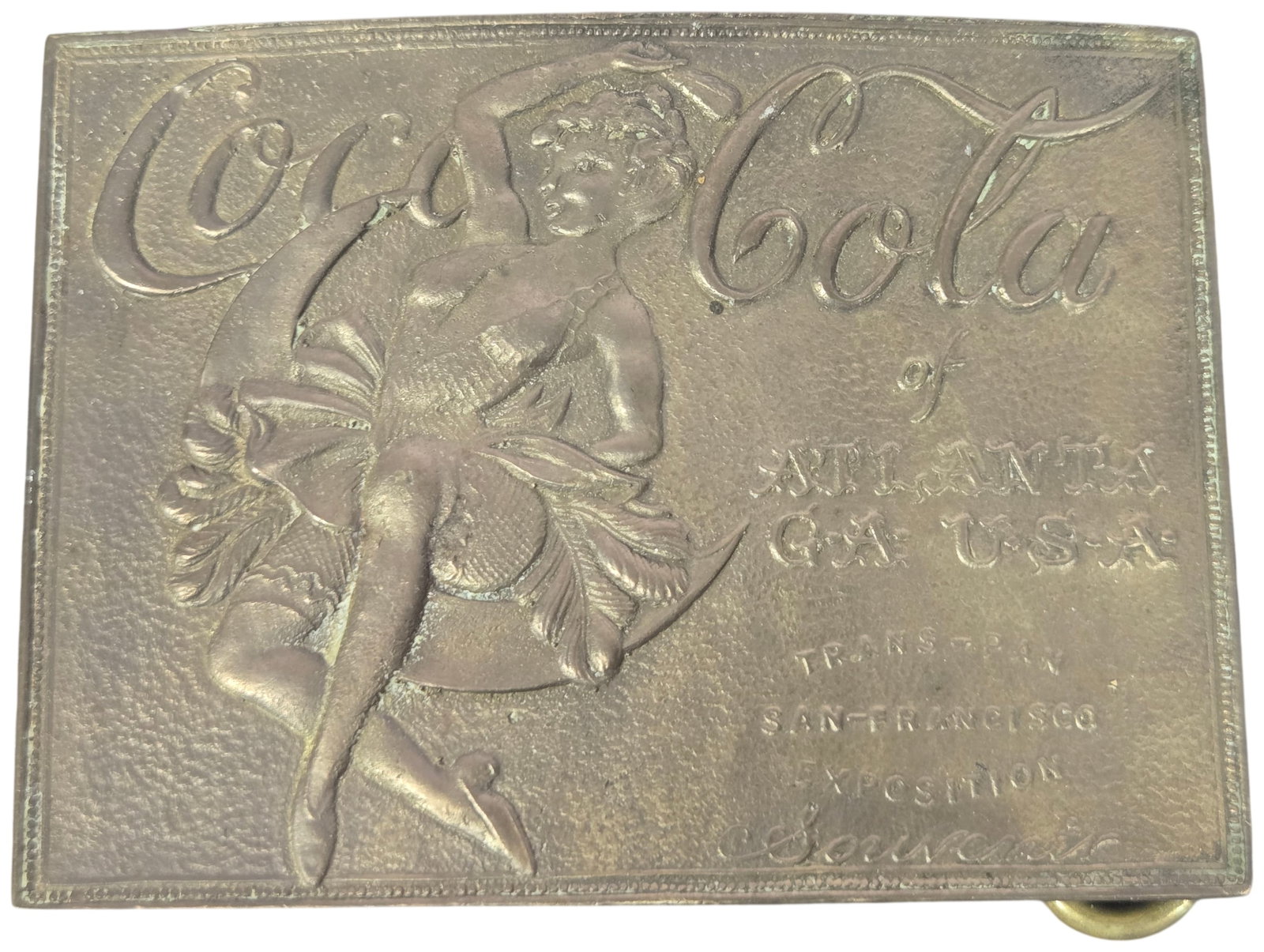 Tiffany Studio New York Brass Coca-Cola Trans-Pan Exposition Souvenir Belt Buckle: This Tiffany Studio New York brass belt buckle is a souvenir piece featuring Coca-Cola advertising. The rectangular cast brass buckle displays a raised relief of a woman in a showgirl costume with a f
