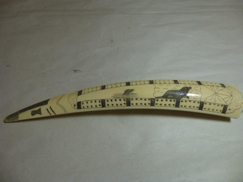 Eskimo Walrus Tusk Cribbage Board: With Scrimshaw decoration of seals, and a large fractured iceberg. Cribbage board measures 11.5" in total. No international or California shipping. Shipping 20.