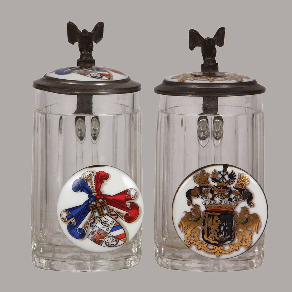 Student steins (two), glass, .3L : Student steins (two), glass, .3L, pressed, porcelain inlaid lids: student society, Corps Rhenania, Heidelberg, 1927; with, family coat-of-arms, members of Corps Guestphalia, Heidelberg, 1924 -1925, bo