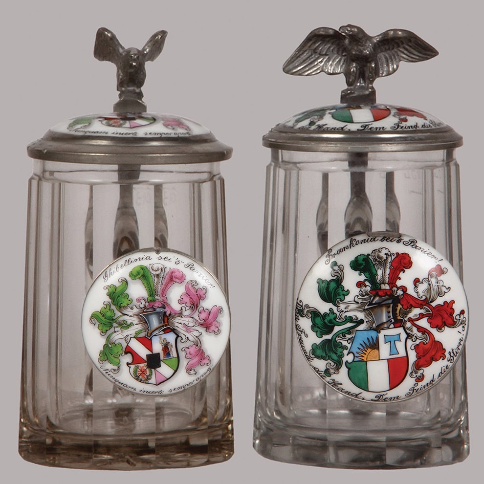 Student steins, two, glass, .3L : Student steins, two, glass, .3L, blown, cut, faceted, porcelain inlaid lids: Ghibellinia sei's Panier! 1903; with, Frankonia sei's Panier! 1914, both mint.