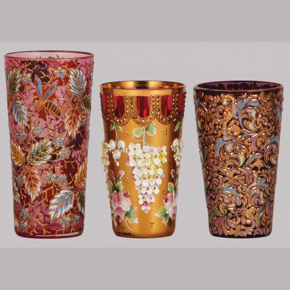 Ludwig Moser glass tumblers, three, 3.9" to 4.6" ht.: Ludwig Moser glass tumblers, three, 3.9" to 4.6" ht., blown, pink, cranberry & purple colors, hand-painted, floral decor on each, tallest tumbler also has bugs, all gilded, all in mint condition.