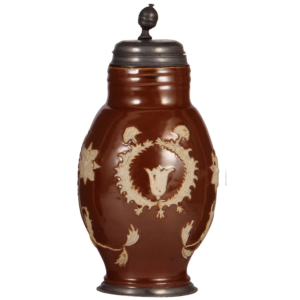 Bunzlauer Melonenkrug, c.1800.: Bunzlauer Melonenkrug, 13.5'' ht., c.1800, brown glaze, applied relief, floral decoration pewter lid, vertical handle strap & footring, lid dated 1793, thumblift bent, body very good condition.