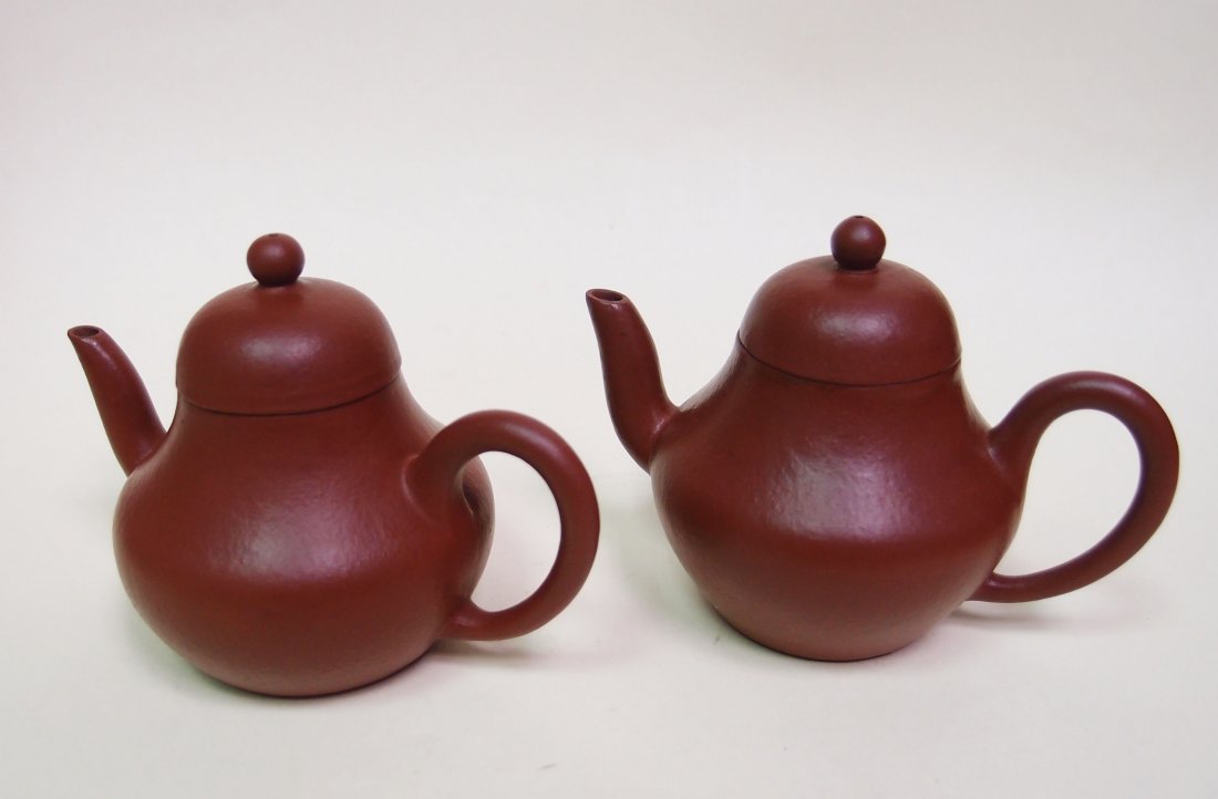 A Pair of "Siting" Teapots: Size: 7.3cm high and 9.6cm long from spout to handle