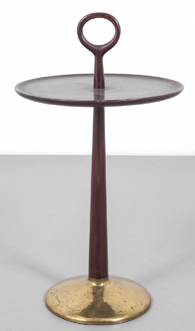 UN TAVOLINO DI SERVIZIO, anni '50. Ottone,: UN TAVOLINO DI SERVIZIO, anni '50. Ottone, legno di mogano tornito tinto all'anilina. Altezza cm 72, diametro cm 40.