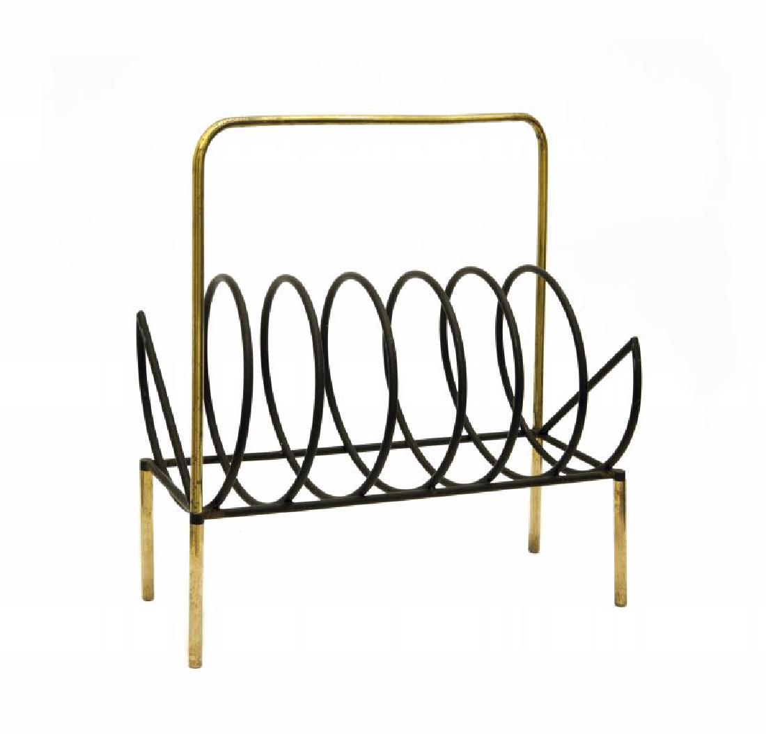 UN PORTARIVISTE, anni "50. Tubo di ottone,: UN PORTARIVISTE, anni "50. Tubo di ottone, tondino di ferro verniciato. Cm 48 (h) x 43 x 20.